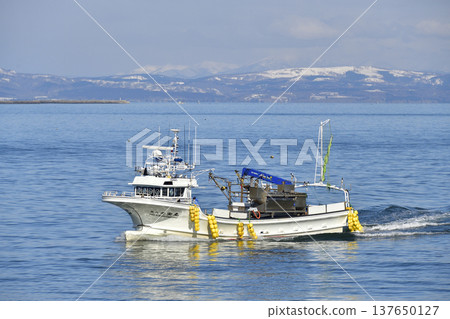 A photograph of fishing boats returning to Otobe Fishing Port in Yakumo Town, Hokkaido, in early spring. A photograph of fishing boats returning to Otobe Fishing Port in Yakumo Town, Hokkaido, in early spring. 137650127