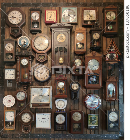 A decorative wall filled with antique and vintage clocks mounted on an aged wooden surface, showcasing historic timepieces and classic interior decoration A decorative wall filled with antique and vintage clocks mounted on an aged wooden surface, showcasing historic timepieces and classic interior decoration 137650196