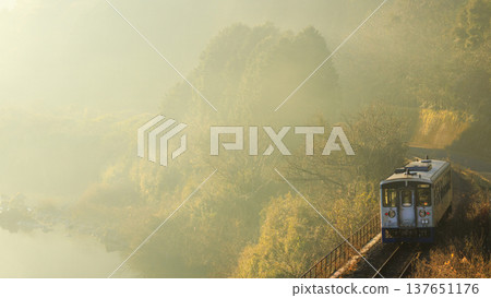 一列行駛在淀線的柴油車組沿著四萬十川行駛，這條河是日本最後一條保存完好的河流，沐浴在強烈的逆光晨光中。 137651176