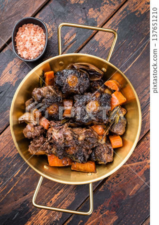 Homemade beef oxtail ragout in pan, gelatin rich slow cooked meat with vegetables in dark sauce, overhead shot Homemade beef oxtail ragout in pan, gelatin rich slow cooked meat with vegetables in dark sauce, overhead shot 137651210