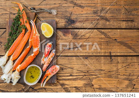 Premium red kamchatka crab legs steamed and cleaned with butter sauce on dark wooden background seafood delicacy Premium red kamchatka crab legs steamed and cleaned with butter sauce on dark wooden background seafood delicacy 137651241