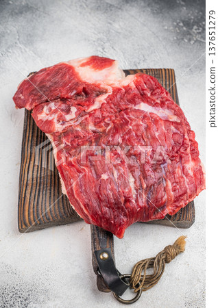 Raw beef brisket on wooden board with butcher tools, fresh uncooked meat cut ideal for barbecue, smoking and slow roasting 137651279