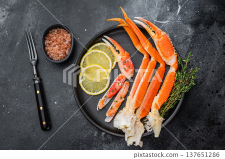 Premium alaskan king crab seafood with lemon and thyme on black dish dark stone surface restaurant style copy space Premium alaskan king crab seafood with lemon and thyme on black dish dark stone surface restaurant style copy space 137651286