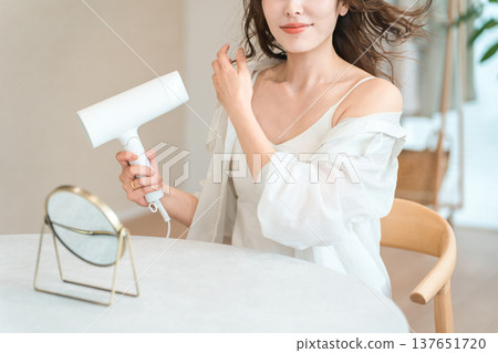 女人用吹風機吹乾頭髮（護髮） 137651720