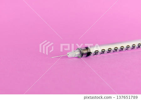 Medical syringe with needle isolated on a vibrant pink background for cosmetic beauty procedures. Close-up studio shot of a sterile disposable syringe used for facial injections, filler treatments 137651789