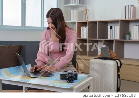 Remote Work. Young woman using laptop for travel planning at home. Remote Work. Young woman using laptop for travel planning at home. 137653198