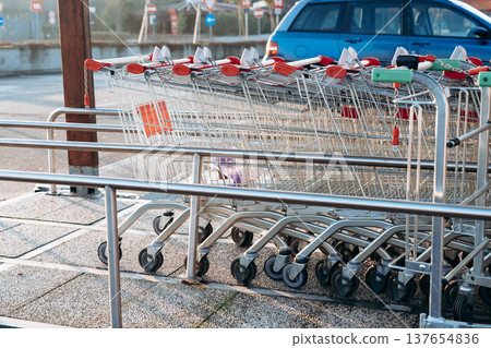 Shopping carts lined up at a parking area near a store in the early morning hours Shopping carts lined up at a parking area near a store in the early morning hours 137654836