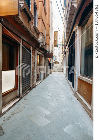 Narrow street in Venice showing closed shops and steps leading away in the distance Narrow street in Venice showing closed shops and steps leading away in the distance 137654863
