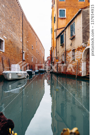 Quiet canal view with boats and buildings in Venice during the day 137654915