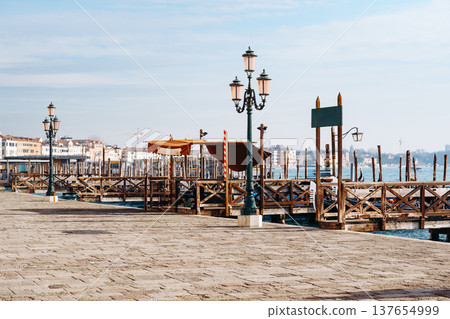 Visitors walk along the waterfront on a calm day by the dock in the city Visitors walk along the waterfront on a calm day by the dock in the city 137654999