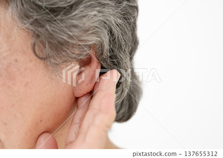 Senior woman touching her ear Senior woman touching her ear 137655312