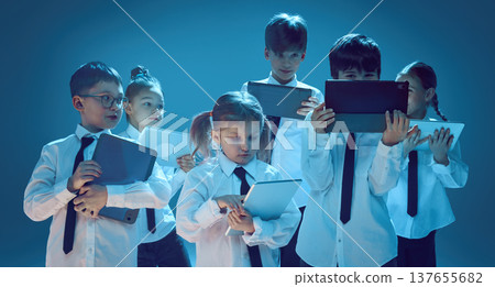 Kids using tablet devices together in neon studio Kids using tablet devices together in neon studio 137655682
