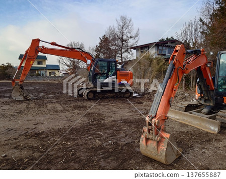 Hydraulic excavators in use at civil engineering sites 137655887