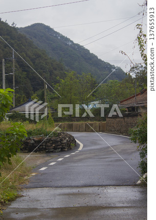 This is a rural road scene on a cloudy day. This is a rural road scene on a cloudy day. 137655913