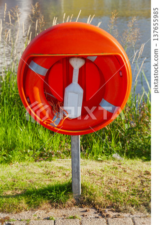 Emergency lifebuoy safety ring beside lake water Emergency lifebuoy safety ring beside lake water 137655985
