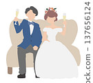 The bride and groom toast while sitting on the sofa. 137656124