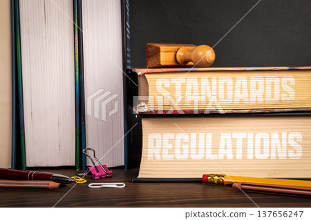 STANDARDS REGULATIONS Books Stack With Stamp Compliance Concept STANDARDS REGULATIONS Books Stack With Stamp Compliance Concept 137656247