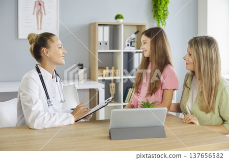 Child and mother discussing health with pediatric doctor in bright family clinic Child and mother discussing health with pediatric doctor in bright family clinic 137656582