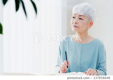 Senior women writing end-of-life notebooks 137656646