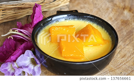 mango mousse pudding in a cup sits on a table in the cafe. 137656661