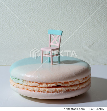 Small chair on top of a macaron in a creative setup with pastel colors and simple background 137656907