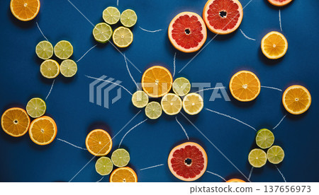Slices of different citrus fruits arranged on a blue surface connected by chalk lines in a creative layout 137656973