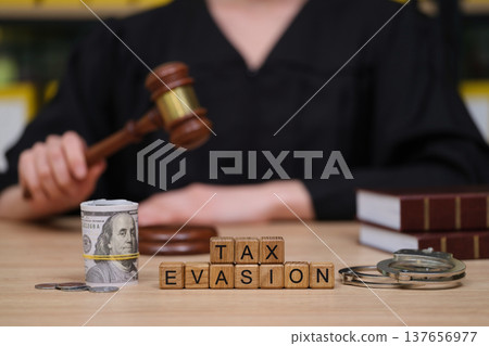Courtroom scene showcasing tax evasion with judge, gavel, and money highlighting legal consequences Courtroom scene showcasing tax evasion with judge, gavel, and money highlighting legal consequences 137656977