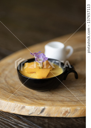 mango mousse pudding in a cup sits on a table mango mousse pudding in a cup sits on a table 137657113