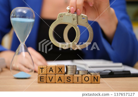 Exploring the consequences of tax evasion with handcuffs and coins in a busy office setting Exploring the consequences of tax evasion with handcuffs and coins in a busy office setting 137657127