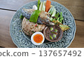 Thai fried rice with shrimp paste, topped with fried mackerel, vegetables, and egg. 137657492