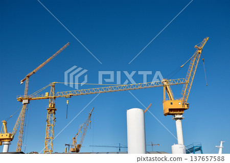 Yellow shipyard crane towering under clear blue sky in Vigo industrial port 137657588