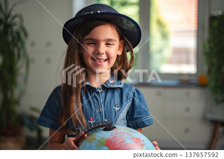 Smiling student holding a globe is learning geography 137657592