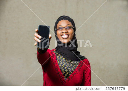 close-up of young muslim woman with happy mobile phone. close-up of young muslim woman with happy mobile phone. 137657779