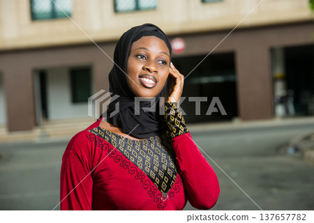 close up of young muslim woman with mobile phone, smiling. close up of young muslim woman with mobile phone, smiling. 137657782