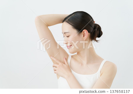 一位年輕的日本女性面帶微笑,一隻手放在身體一側,背景為白色;脫毛圖片。 一位年輕的日本女性面帶微笑,一隻手放在身體一側,背景為白色;脫毛圖片。 137658137