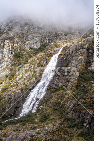 Waterfall cascading from snowy mountains on the Laguna 69 trek, Peru 137658274