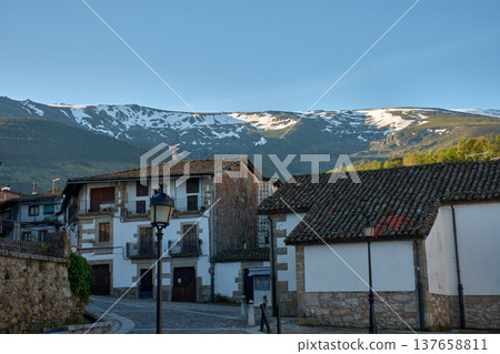 Traditional houses in the village of Candelario, Salamanca, with old tiled roofs and the snow-capped mountains in the background, in a rural and mountainous setting Traditional houses in the village of Candelario, Salamanca, with old tiled roofs and the snow-capped mountains in the background, in a rural and mountainous setting 137658811