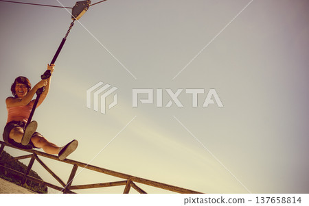 Adult woman having fun on zipline Adult woman having fun on zipline 137658814