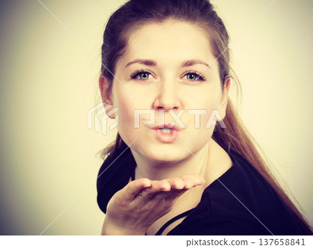 Portrait of happy attractive woman sending air kiss Portrait of happy attractive woman sending air kiss 137658841