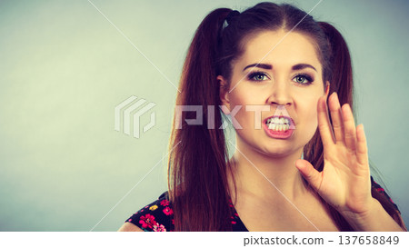 Angry teenager girl with brown hair ponytails 137658849