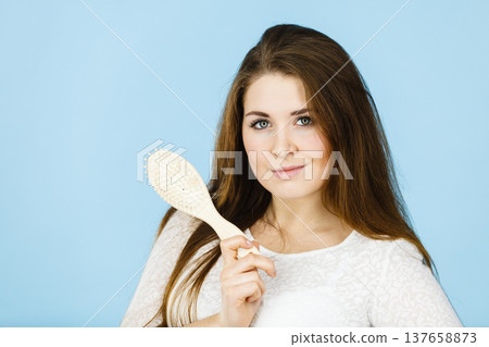 Happy woman brushing her hair Happy woman brushing her hair 137658873