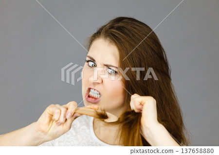 Angry woman trying to brush her hair Angry woman trying to brush her hair 137658880