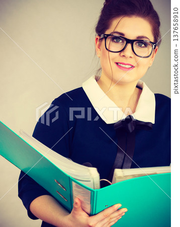 Happy positive business woman holding binder with documents 137658910
