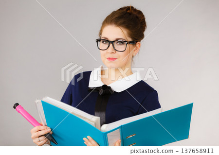 Happy positive business woman holding binder with documents Happy positive business woman holding binder with documents 137658911
