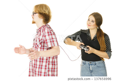 Woman controling man using gaming pad Woman controling man using gaming pad 137658996