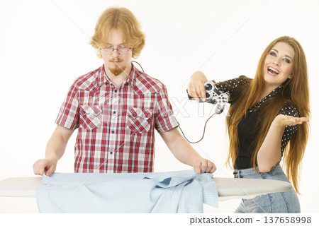 Woman controling man to do ironing Woman controling man to do ironing 137658998