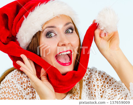 Excited woman in christmas santa hat Excited woman in christmas santa hat 137659009