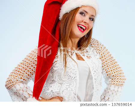Smiling woman in christmas santa hat Smiling woman in christmas santa hat 137659014