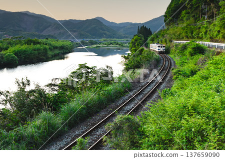 Nichinan Line Kiha 40 running through the fresh greenery of the Hiroto River in Kitago Town, Nichinan City, Miyazaki Prefecture 137659090