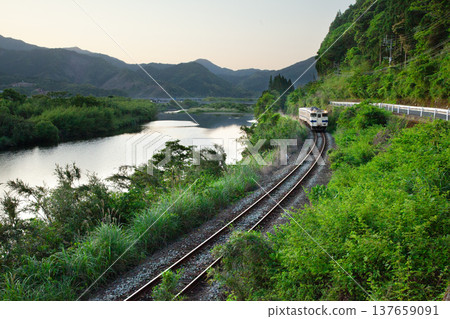 Nichinan Line Kiha 40 running through the fresh greenery of the Hiroto River in Kitago Town, Nichinan City, Miyazaki Prefecture 137659091